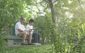 Senior couple sitting on bench, reading their phones in the park Royalty Free Stock Photo