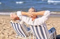 Senior couple sitting on chairs at summer beach Royalty Free Stock Photo