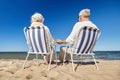 Senior couple sitting on chairs at summer beach Royalty Free Stock Photo