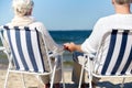 Senior couple sitting on chairs at summer beach Royalty Free Stock Photo