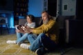 Senior couple sitting on floor and playing video game on console Royalty Free Stock Photo