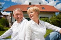 Senior couple sitting in front of their home Royalty Free Stock Photo