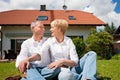 Senior couple sitting in front of their home Royalty Free Stock Photo