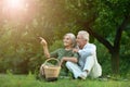 Senior couple sitting on the grass in the park. woman pointing Royalty Free Stock Photo