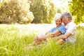 Senior couple sitting on grass together relaxing Royalty Free Stock Photo