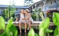 Senior couple sitting outdoors by lake hotel on holiday, having fun. Royalty Free Stock Photo