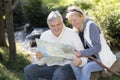 Senior couple sitting outdoors with map Royalty Free Stock Photo