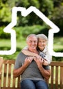 Senior couple sitting in the park with home outline