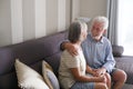 Senior couple sitting on the sofa at home having care each other and enjoy bright day smiling and hugging with love and serene Royalty Free Stock Photo