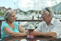 Senior couple sitting on table on the pier