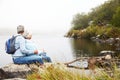 Senior couple sitting together by a lake admiring the view