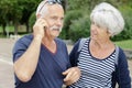 Senior couple with smartphone outside