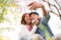 Senior couple with smartphone outside in spring nature. Royalty Free Stock Photo