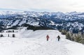 Senior couple is snowshoe hiking in alpine snow winter mountains. Allgau, Bavaria, Germany. Royalty Free Stock Photo