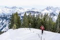 Senior couple is snowshoe hiking in alpine snow winter mountains. Allgau, Bavaria, Germany. Royalty Free Stock Photo