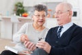 Senior couple in sofa reading official documents Royalty Free Stock Photo