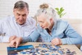 Senior couple solving jigsaw puzzle together at home Royalty Free Stock Photo