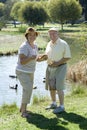 Senior Couple Standing By Duckpond Royalty Free Stock Photo