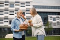 Senior couple standing on a grass in summer with straw basket and flowers Royalty Free Stock Photo