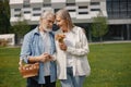 Senior couple standing on a grass in summer with straw basket and flowers Royalty Free Stock Photo