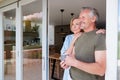 Senior Couple Standing And Looking Out Of Kitchen Door Drinking Coffee Royalty Free Stock Photo