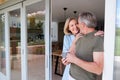 Senior Couple Standing And Looking Out Of Kitchen Door Drinking Coffee Royalty Free Stock Photo