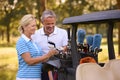 Senior Couple Standing Next To Buggy On Golf Course Choosing Clubs Together Royalty Free Stock Photo