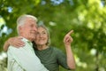 Senior couple in summer park, woman ponting