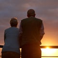 Senior couple, sunset and together on balcony in outdoors, bonding and love on vacation or holiday. Back, elderly people