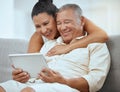 Senior couple, tablet and online in living room, social media news and ebook media app in Colombia home. Elderly Royalty Free Stock Photo