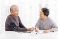 Senior couple taking blood pressure in living room Royalty Free Stock Photo