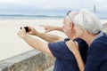 Senior couple taking picture on beach Royalty Free Stock Photo