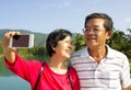 Senior couple taking picture by themselves in outdoor Royalty Free Stock Photo