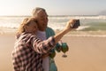 Senior couple taking selfie with mobile phone while having cocktail drink on the beach Royalty Free Stock Photo