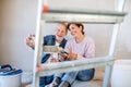 Senior couple taking selfie when painting walls in new home, relocation concept. Royalty Free Stock Photo