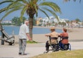 Senior couple talking with friend on the promenade in the sunny day