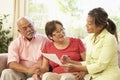 Senior Couple Talking To Financial Advisor At Home