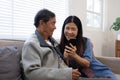 A senior couple in their 60s spends their free time relaxing and having fun together on the sofa in the living room. Royalty Free Stock Photo