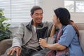 A senior couple in their 60s spends their free time relaxing and having fun together on the sofa in the living room. Royalty Free Stock Photo