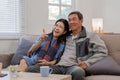 A senior couple in their 60s spends their free time relaxing and having fun together on the sofa in the living room. Royalty Free Stock Photo