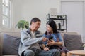 A senior couple in their 60s spends their free time relaxing and having fun together on the sofa in the living room. Royalty Free Stock Photo