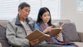 A senior couple in their 60s spends their free time sitting and reading book, relaxing and having fun together on the Royalty Free Stock Photo