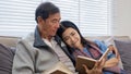 A senior couple in their 60s spends their free time sitting and reading book, relaxing and having fun together on the Royalty Free Stock Photo