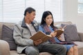 A senior couple in their 60s spends their free time sitting and reading book, relaxing and having fun together on the Royalty Free Stock Photo