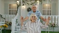 Senior couple together in front yard at home. Man swinging woman during Coronavirus quarantine Royalty Free Stock Photo