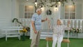 Senior couple together in front yard at home. Man swinging woman. Happy elderly pensioners family Royalty Free Stock Photo