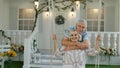 Senior couple together in front yard at home. Man swinging woman. Happy elderly pensioners family Royalty Free Stock Photo