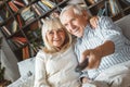 Senior couple together at home retirement concept watching tv switching channels Royalty Free Stock Photo