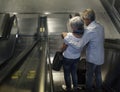 Senior couple tourists at the escalator going down Royalty Free Stock Photo