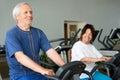 Senior couple training at machine at gym. Royalty Free Stock Photo